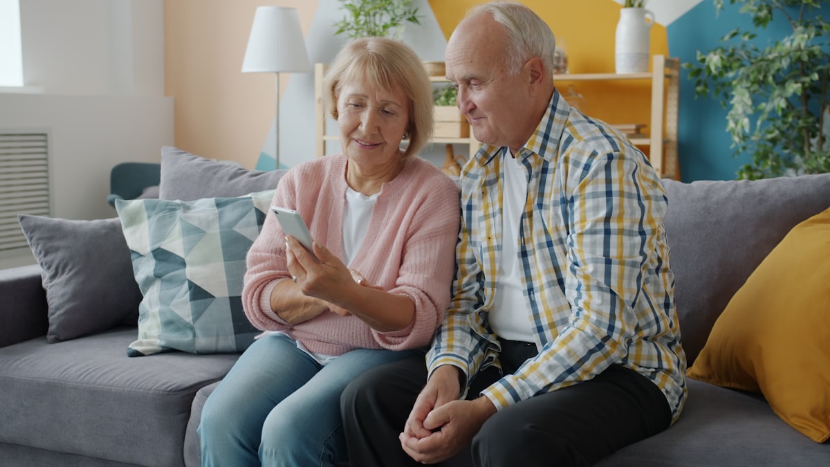 Elderly couple using smartphone together — following a simple step-by-step guide to transfer files from Android to iPhone