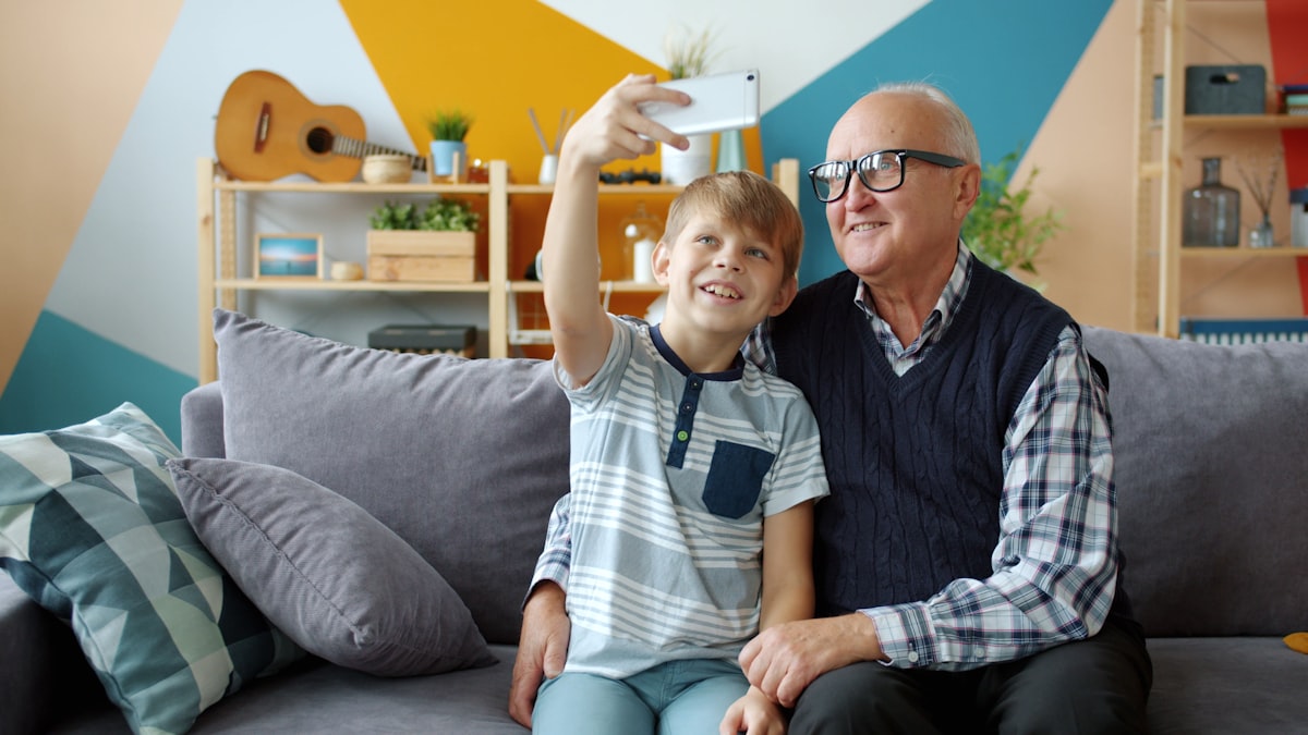 Grandparent and grandchild taking a selfie — sharing family photos across generations with full quality and no platform tracking