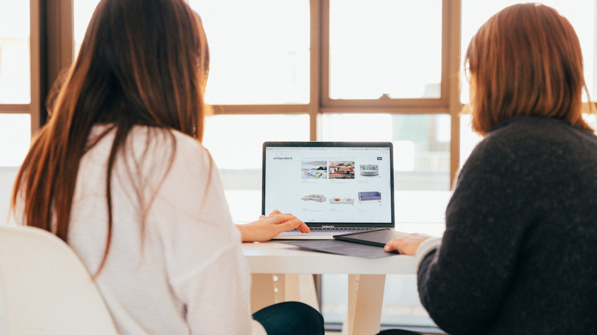 Two people sharing files on a laptop — how account-free file transfer works without creating unnecessary data profiles